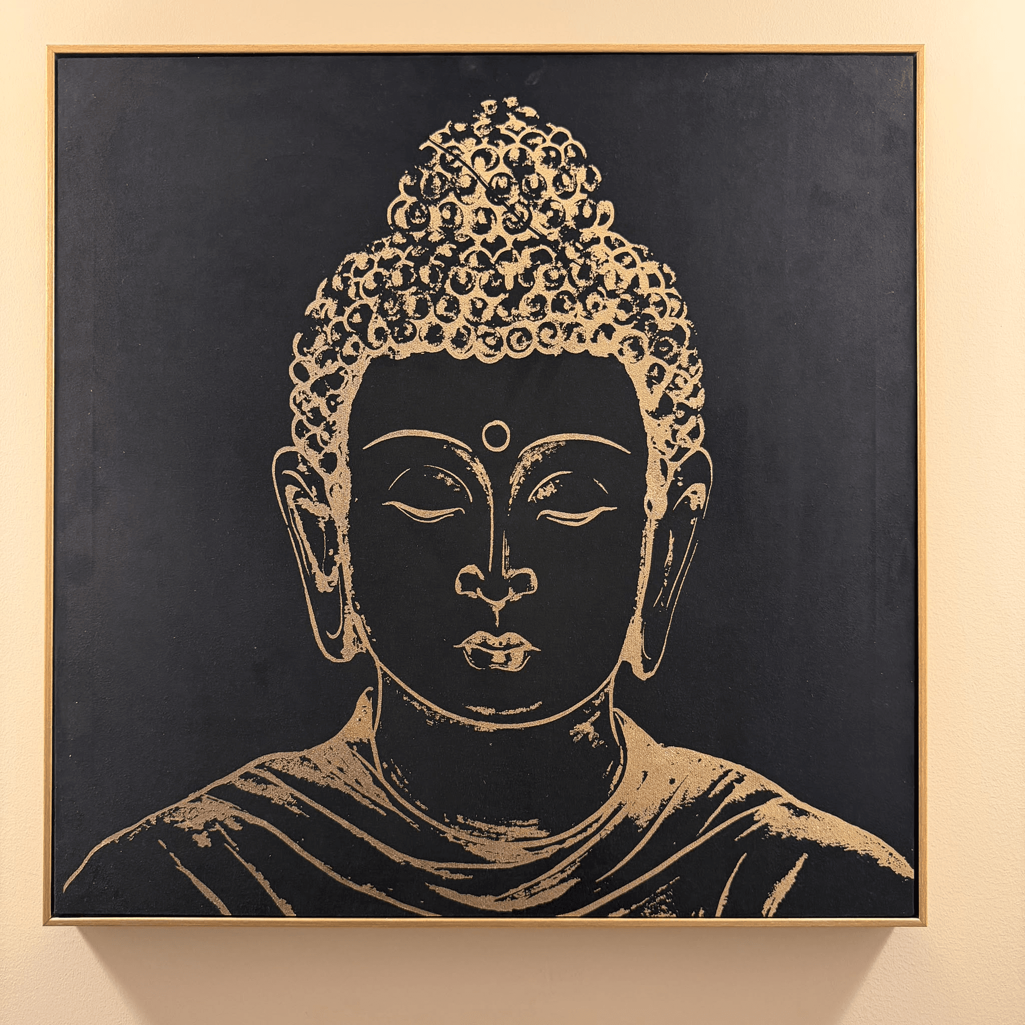 Toile représentant un Bouddha doré sur fond noir, accrochée dans le salon