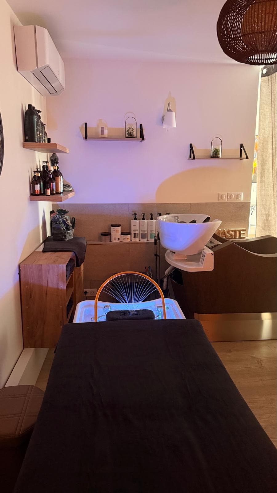 Table de massage préparée face au bac Head Spa et aux étagères de produits